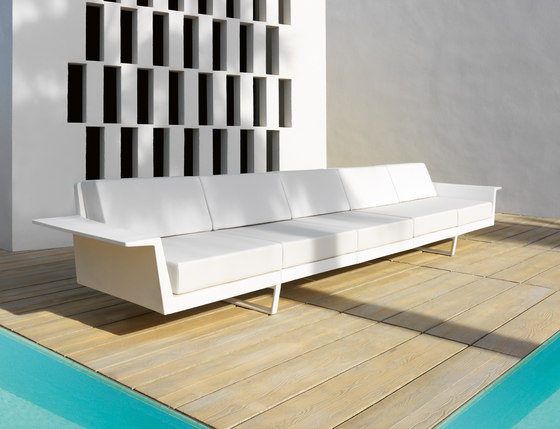 Aluminum Flat Modular Sofa — Modern white sofa on wooden deck by a pool, with geometric wall pattern.