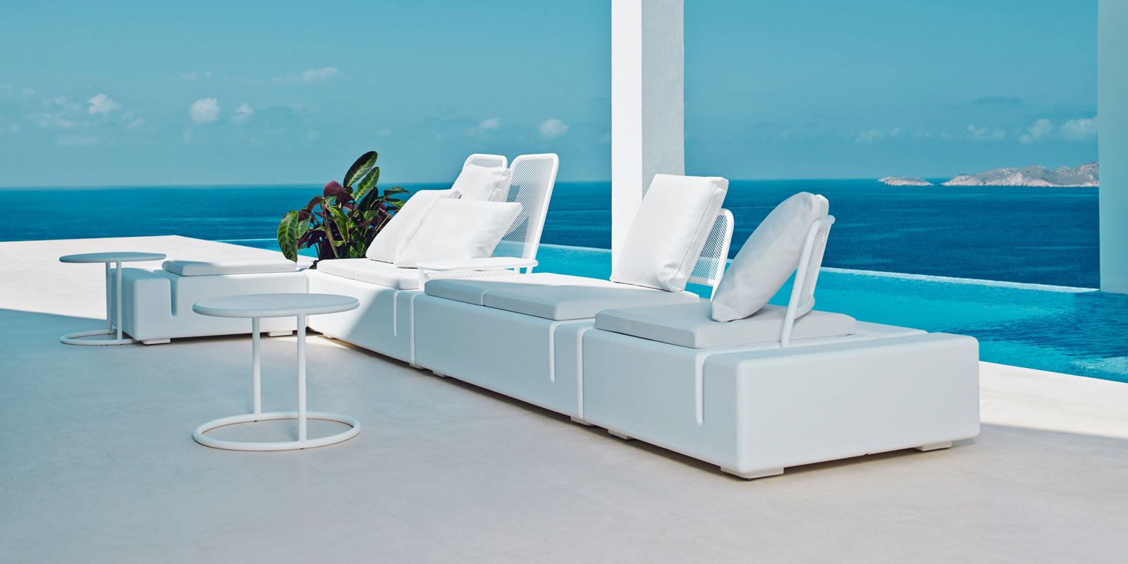 Modern Flat Resin Modular Sofa — Modern white outdoor furniture on a terrace with an infinity pool overlooking the sea.