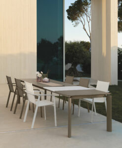 Titus, is a luxury modern outdoor dining table with stone-glass top & stackable dining chairs. This collection is a beauty thanks to its style and unique design.