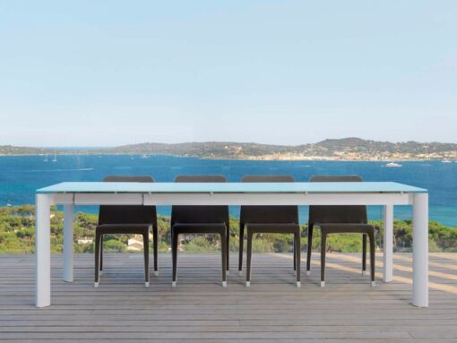 Titus, is a luxury modern outdoor dining table with stone-glass top & stackable dining chairs. This collection is a beauty thanks to its style and unique design.